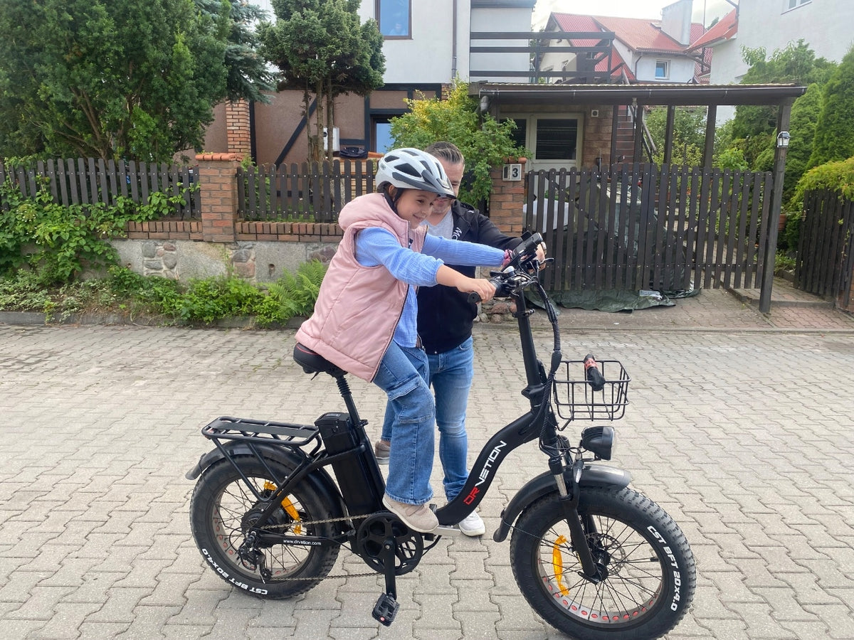 Helmeted rider on a step-through e-bike along a paved path